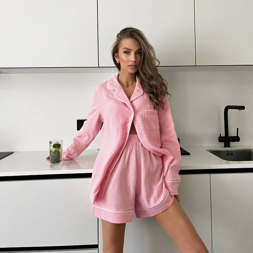 Woman in a pink robe sitting on a table in a modern living room.
