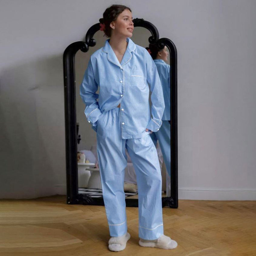 Woman wearing a light blue pajama set standing in front of a mirror.
